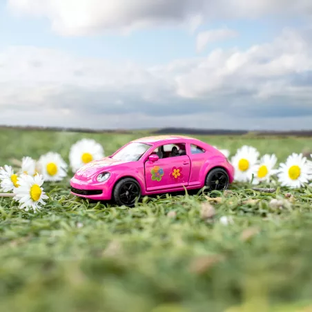 Coche de juguete VW Escarabajo rosa con pegatinas de flores de colores y puertas que se abren.