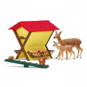 Pesebre de juguete Schleich con figuras de ciervos, ardilla y accesorios de comida para animales del bosque.