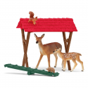Pesebre de juguete Schleich con figuras de ciervos, ardilla y accesorios de comida para animales del bosque.