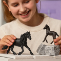 Potro frisón de juguete Schleich con pelaje negro azabache en postura curiosa.
