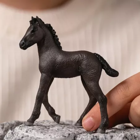 Potro frisón de juguete Schleich con pelaje negro azabache en postura curiosa.