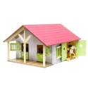 Establo de juguete de madera rosa con dos compartimentos y techo abatible a escala 1:24.